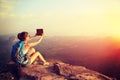 Hiker use digital tablet taking photo at mountain peak cliff Royalty Free Stock Photo