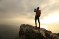 Hiker use digital tablet taking photo on seaside mountain peak rock