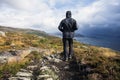 Hiker walking in the mountains on a rainy day, goal succes and freedom. Travling Norway landscape