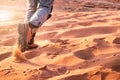 Hiker walking throught sandy desert. Traces in sand. Focus on a man legs. Tourist in a desert. Sandy background.