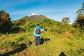 Rear view of a man standing against the background Mount Sabyinyo in the Mgahinga Gorilla National Park, Uganda