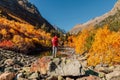 Hiker woman with backpack enjoying view in the autumnal mountains. Rocky mountains and tourist Royalty Free Stock Photo