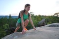 Hiker woman clambering on rocky mountain footpath in evening nature. Lonely female traveler traversing hard wilderness