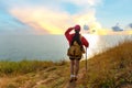 Hiker woman climb up the last section of sunset in mountains near the sea. Traveler walking in outdoor Royalty Free Stock Photo