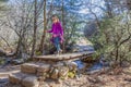 Hiker woman crossing a bridge over a stream in a forest Royalty Free Stock Photo