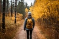 Hiker woman exploring autumn forest trail amidst vibrant fall foliage, embracing active lifestyle