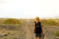 Hiker woman exploring dry region of Lanzarote Island. Young female backpacker with straw hat walking in desolate path of Lanzarote Royalty Free Stock Photo