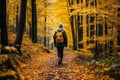 Hiker woman exploring forest hiking trail with vibrant fall foliage background in autumn season