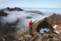 Hiker woman raised hands on mountain summit above clouds travel hiking with backpack outdoor Royalty Free Stock Photo