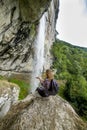 Hiker woman sitting on a rock with backpack while admiring the s Royalty Free Stock Photo