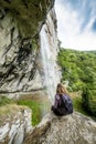 Hiker woman sitting on a rock with backpack while admiring the s Royalty Free Stock Photo