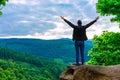 Hiker woman standing with hands up achieving the top