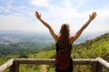 Hiker woman standing with hands up achieving the top. Girl welcomes a sun. Successful woman hiker open arms on mountain top. Girl