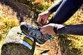 Hiker woman tying her trekking shoes on a hiking stone marking the tourist route Royalty Free Stock Photo