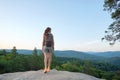 Hiker woman walking on mountain footpath enjoying evening nature. Lonely female traveler traversing wilderness trail