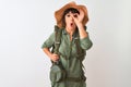 Hiker woman wearing backpack hat and water canteen over isolated white background doing ok gesture shocked with surprised face, Royalty Free Stock Photo