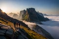 Hikers ascending a steep, rocky incline, with sheer cliffs on one side and a vast valley on the other, shrouded in morning mist Royalty Free Stock Photo