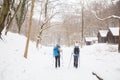 Hikers with backpack hiking on snowy trail. Active people walking together at winter day. Back view