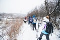 Hikers with backpack hiking on snowy trail. Group of people walking together at winter day Royalty Free Stock Photo