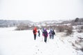 Hikers with backpack hiking on snowy trail. Group of people walking together at winter day Royalty Free Stock Photo