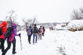 Hikers with backpack hiking on snowy trail. Group of people walking together at winter day Royalty Free Stock Photo