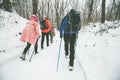 Hikers with backpack hiking on snowy trail. Group of people walking together at winter day. Back view Royalty Free Stock Photo