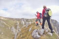 Hikers with backpacks relaxing on top of a mountain and enjoying the view of valley Royalty Free Stock Photo