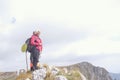 Hikers with backpacks relaxing on top of a mountain and enjoying the view of valley Royalty Free Stock Photo