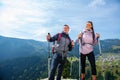 Hikers with backpacks relaxing on top of a mountain and enjoying the view of valley Royalty Free Stock Photo