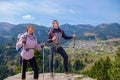 Hikers with backpacks relaxing on top of a mountain and enjoying the view of valley Royalty Free Stock Photo