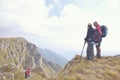 Hikers with backpacks relaxing on top of a mountain and enjoying the view of valley Royalty Free Stock Photo