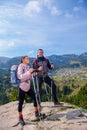 Hikers with backpacks relaxing on top of a mountain and enjoying the view of valley Royalty Free Stock Photo