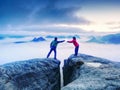 Couple hold light high above danger gulch between rocks