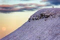 Hikers climbing a mountain summit at sunset with a moonrise behind (Pen-y-Fan, Brecon Beacons Royalty Free Stock Photo