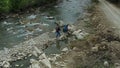 Hikers crossing river drone view cloudy spring day looking adventure vacation Royalty Free Stock Photo