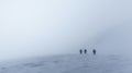 Hikers at distance during a strong blizzard