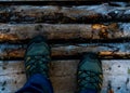 Hikers feet with boots standing on wood paved path