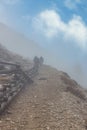 Hikers going up the mountain in fog in Dolomites Royalty Free Stock Photo