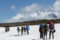 Hikers group trekking in mountains on background of volcanoes