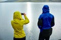 Hikers on the Lake coast with mountain reflection, Iceland Royalty Free Stock Photo