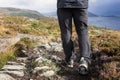 Hikers legs in trekking boots in the mountains, traveling in Norway landscape