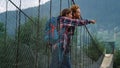 Hikers look mountains view landscape. Couple backpackers stand on river bridge.