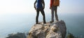 Hikers looking at the view on seaside mountain top rock edge Royalty Free Stock Photo