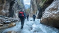 Hikers navigating a river in a narrow canyon, showcasing adventure and nature exploration Royalty Free Stock Photo