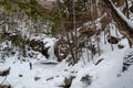 Hikers near frozen Kinsman Falls in Franconia Notch State Park during winter . New Hampshire mountains. USA Royalty Free Stock Photo