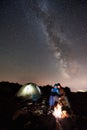 Hikers resting at night camp in mountains under starry sky Royalty Free Stock Photo
