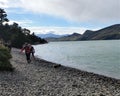 Hikers on a rocky lake beach on the W Trek in Torres del Paine NP in Patagonia, Chile Royalty Free Stock Photo