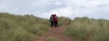 Hikers at Sandwood Bay, Highlands of Scotland. Remote bay with white sand, dunes and reeds.