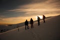 Hikers silhouette at dawn on Mount Ciucas in winter watching the sunset