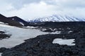 Hikers on snow and black lava landscape close to Tolbachik volcano in the far east peninsula of Kamchatka in Russia